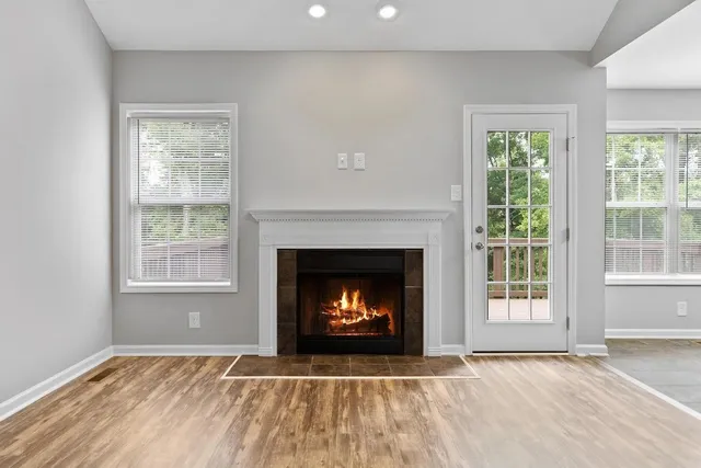 a view of an empty room with a fireplace and a window