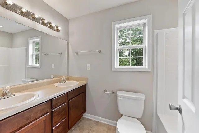 a bathroom with a toilet a sink and mirror