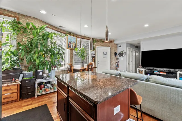 a kitchen with stainless steel appliances granite countertop a sink a counter top space and living room view