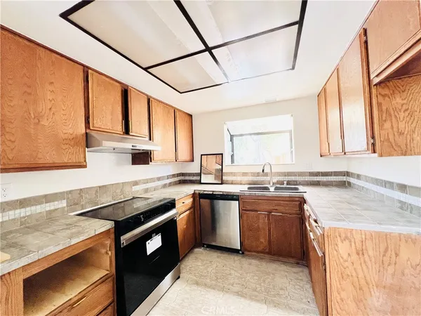 a kitchen with stainless steel appliances granite countertop a sink stove and cabinets