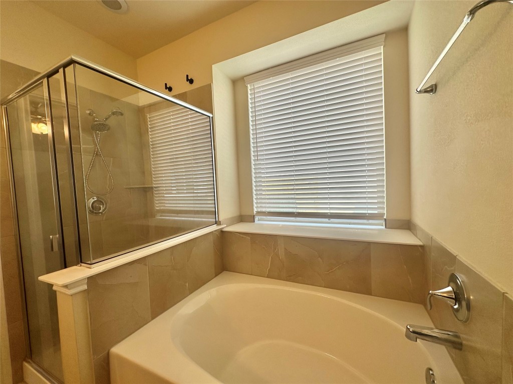 8164 Daisy Cutter Crossing Georgetown, TX 78626 - Photo 14 of 19 a bathroom with a bathtub and shower