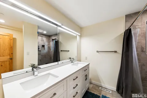 a bathroom with a double vanity sink and mirror
