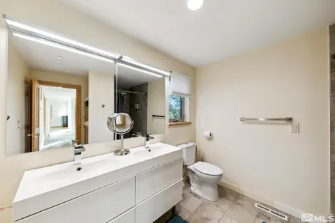 a bathroom with a toilet a sink and mirror