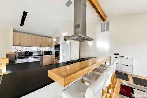 a kitchen with stainless steel appliances kitchen island granite countertop a sink and white cabinets