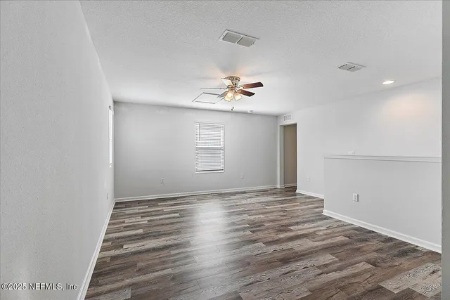 a view of a livingroom with wooden floor and a ceiling fan