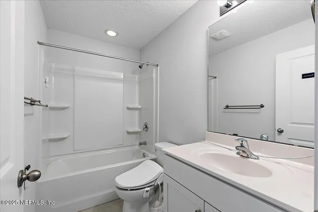 a bathroom with a sink toilet vanity and shower