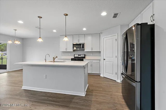 a kitchen with kitchen island a refrigerator a sink and a stove