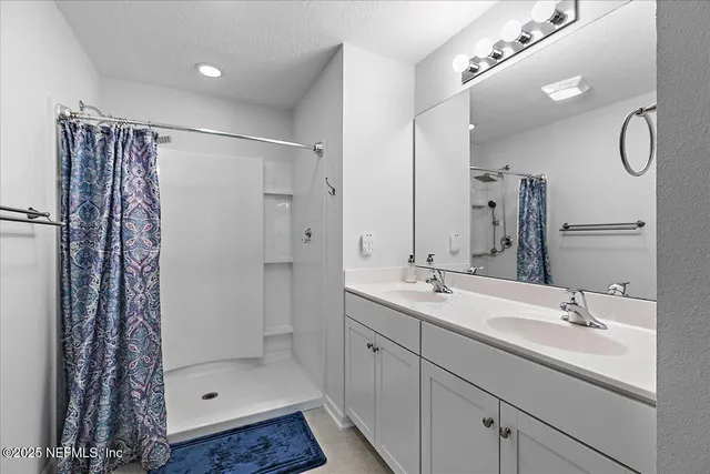a bathroom with a shower sink and mirror