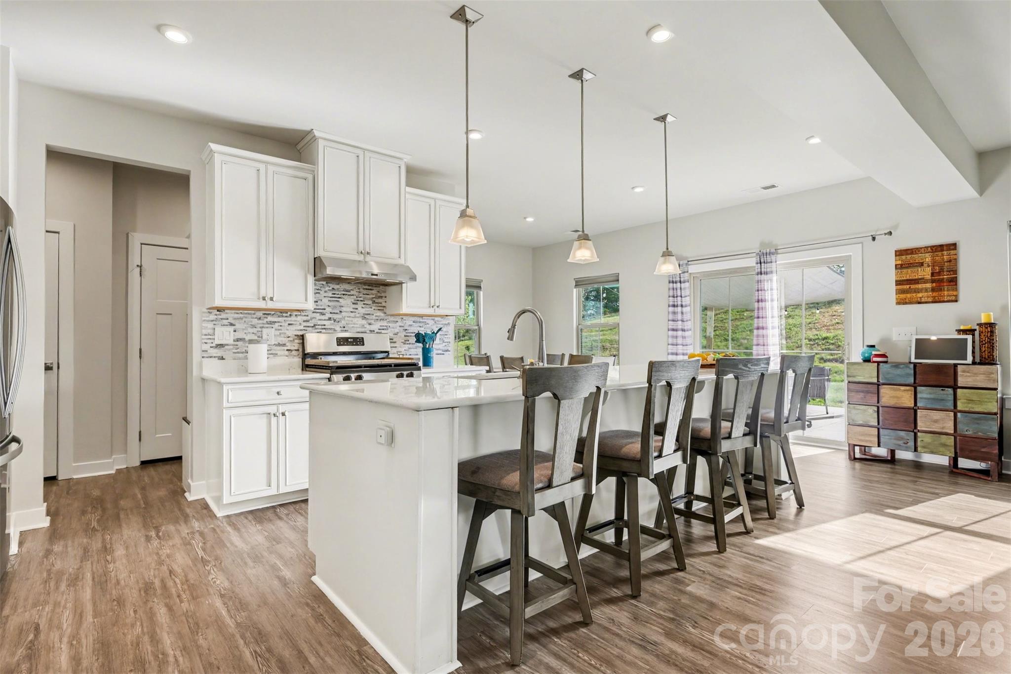 1840 Scarbrough Circle Southwest Concord, NC 28025 - Photo 8 of 29 a kitchen with stainless steel appliances kitchen island granite countertop a table chairs sink and cabinets