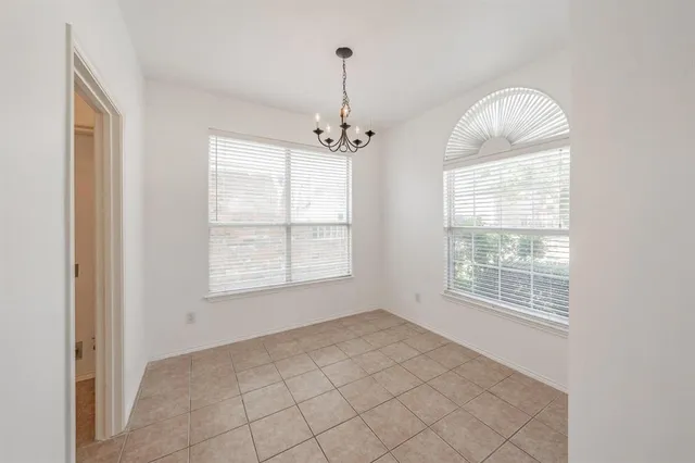an empty room with windows and chandelier