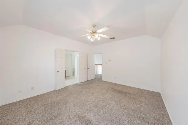 a view of an empty room with a ceiling fan