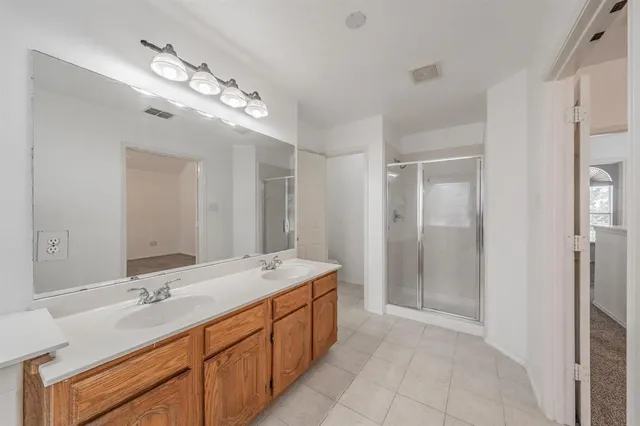 a bathroom with a double vanity sink a large mirror and a shower