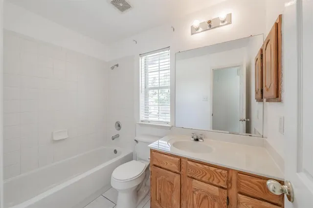 a bathroom with a granite countertop sink a toilet and shower