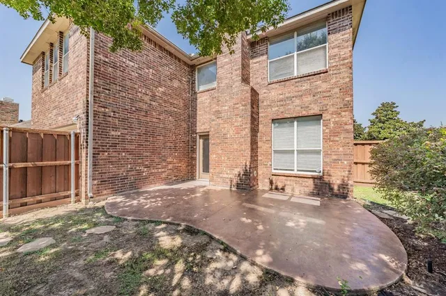 a view of a brick house with many windows and a tree