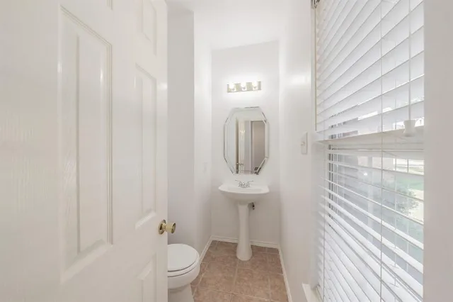 a bathroom with a sink a toilet and shower curtain