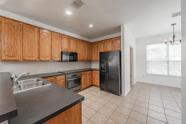 a kitchen with stainless steel appliances granite countertop a refrigerator a stove a sink and dishwasher