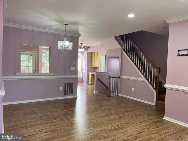a view of a livingroom with wooden floor and furniture