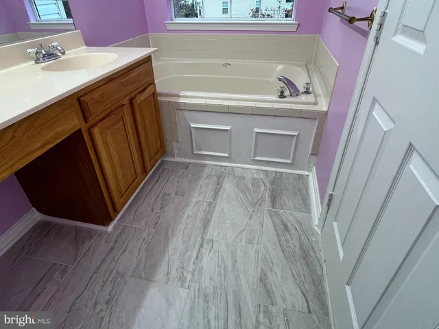 a bathroom with a sink a vanity and a bathtub