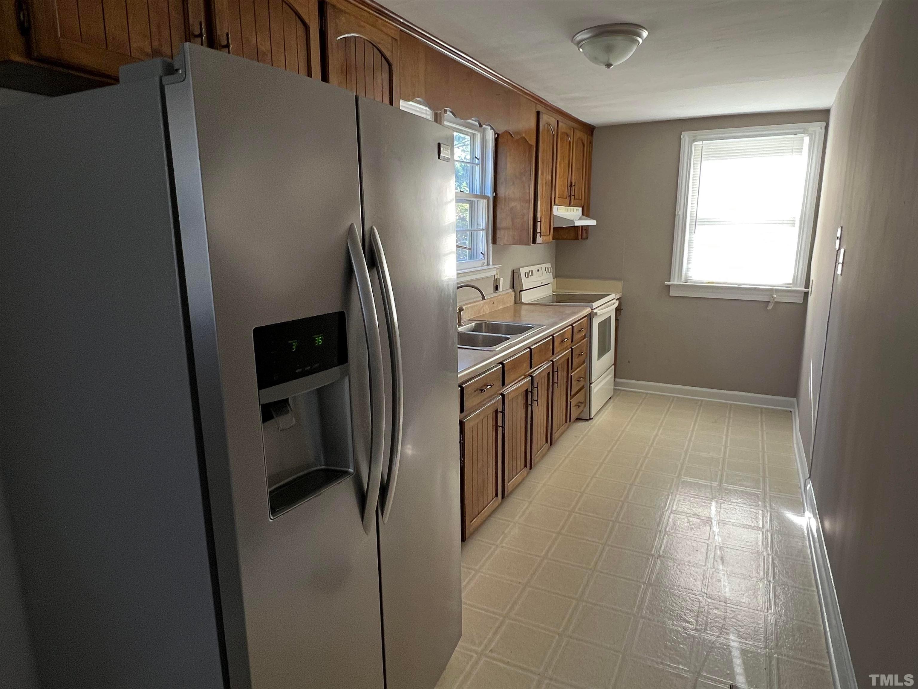4359 Old Poole Road Raleigh, NC 27610 - Photo 12 of 13 a kitchen with stainless steel appliances a refrigerator sink and stove