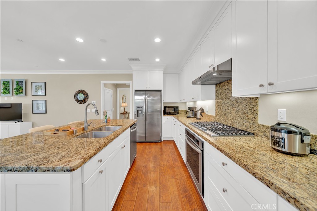 75 Gardenstone Path Irvine, CA 92620 - Photo 20 of 65 a large kitchen with granite countertop a lot of counter space and wooden floor