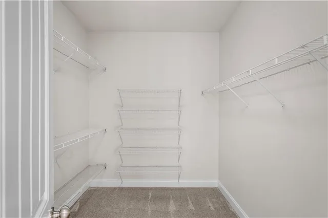 an empty room with wooden floor chandelier and windows