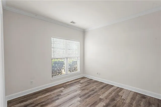 a view of empty room with fireplace and wooden floor