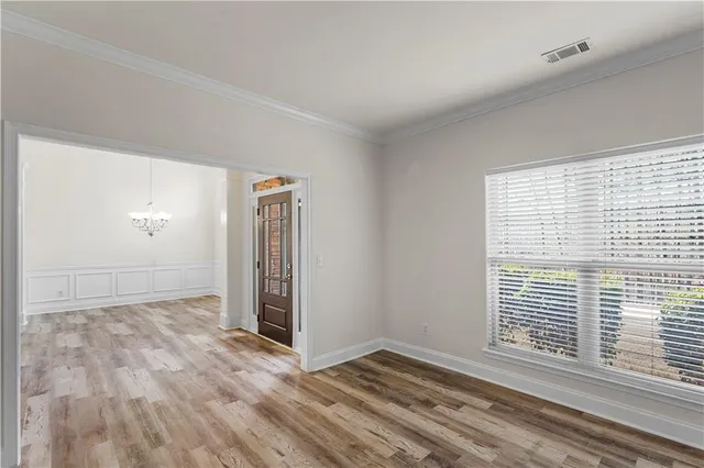 a view of an empty room with wooden floor fireplace and a window