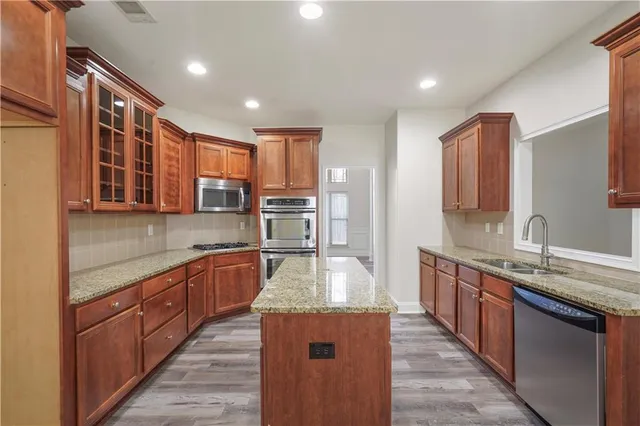 a kitchen with stainless steel appliances granite countertop a sink stove and refrigerator