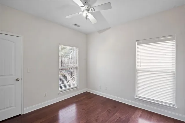 a bathroom with a granite countertop toilet a sink and a mirror