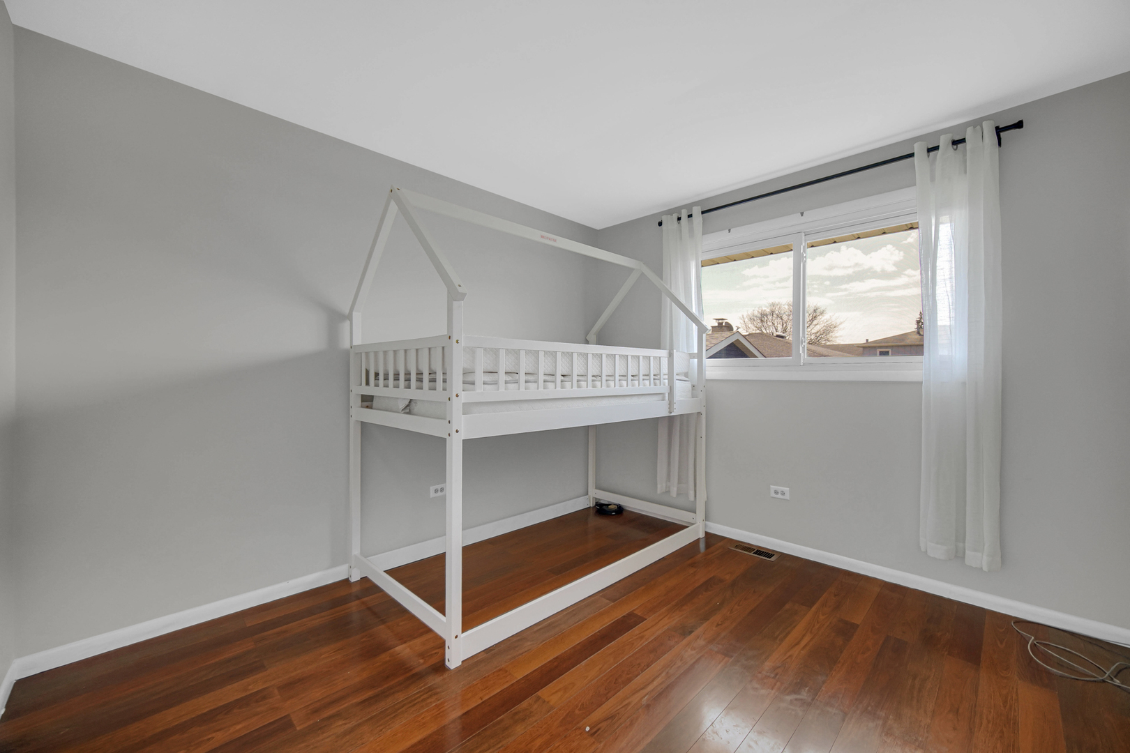7305 West 75th Street Bridgeview, IL 60455 - Photo 12 of 22 a view of an empty room with wooden floor and a window