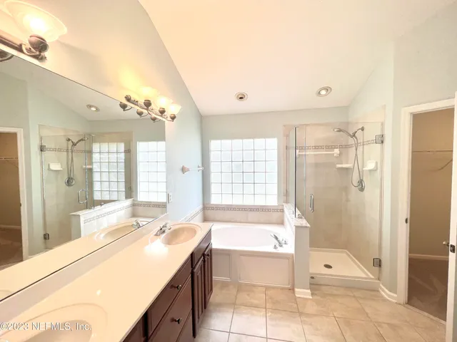 a spacious bathroom with a tub shower and sink