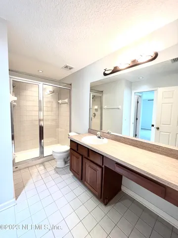 a spacious bathroom with a granite countertop sink mirror and a bathtub