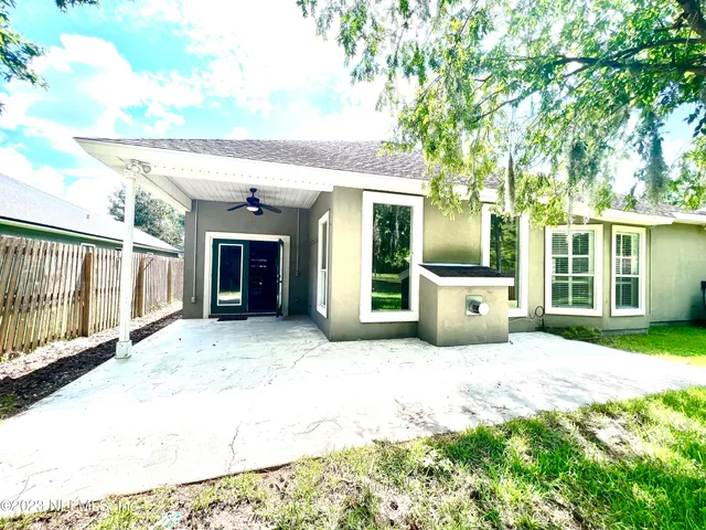 a view of a house with glass doors and yard