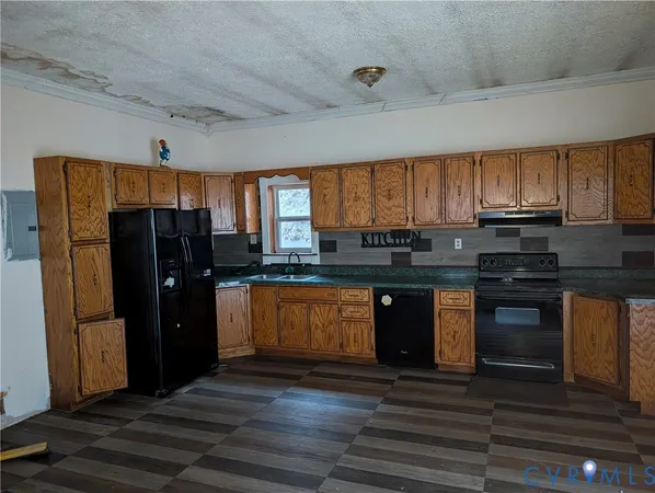 a kitchen with granite countertop a refrigerator a stove and a microwave oven