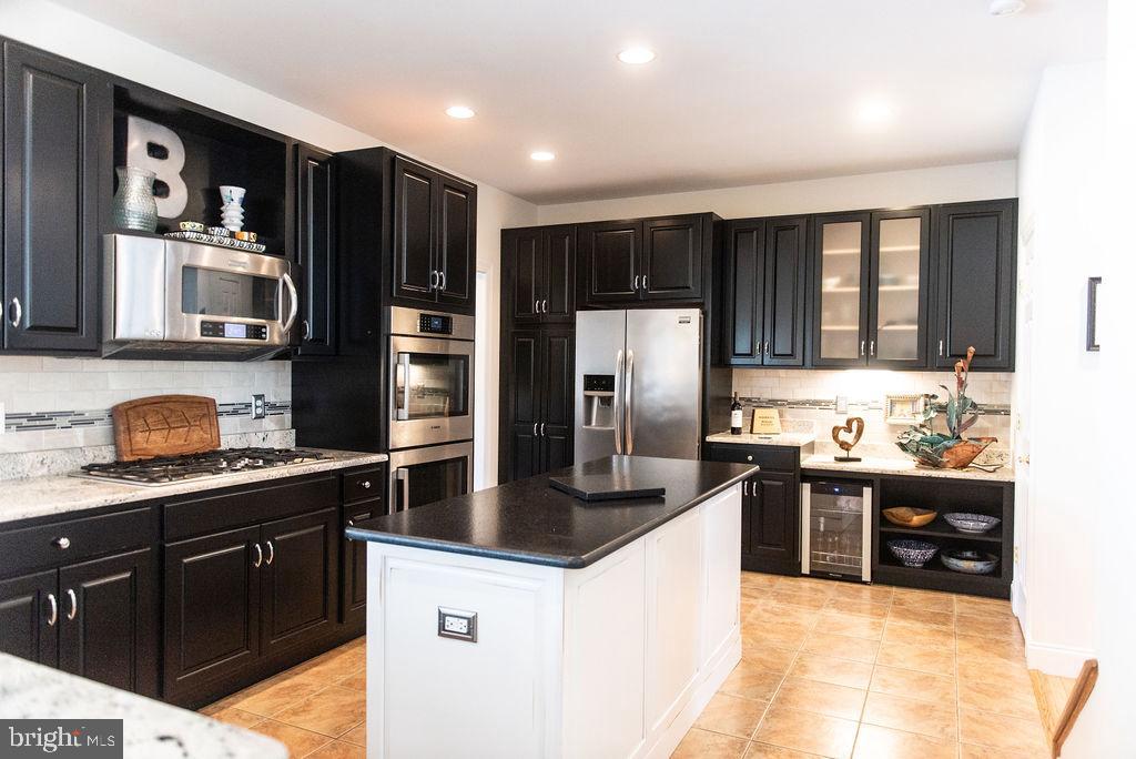 565 Sand Hill Road Hershey, PA 17033 - Photo 5 of 27 a kitchen with granite countertop a refrigerator and a stove top oven