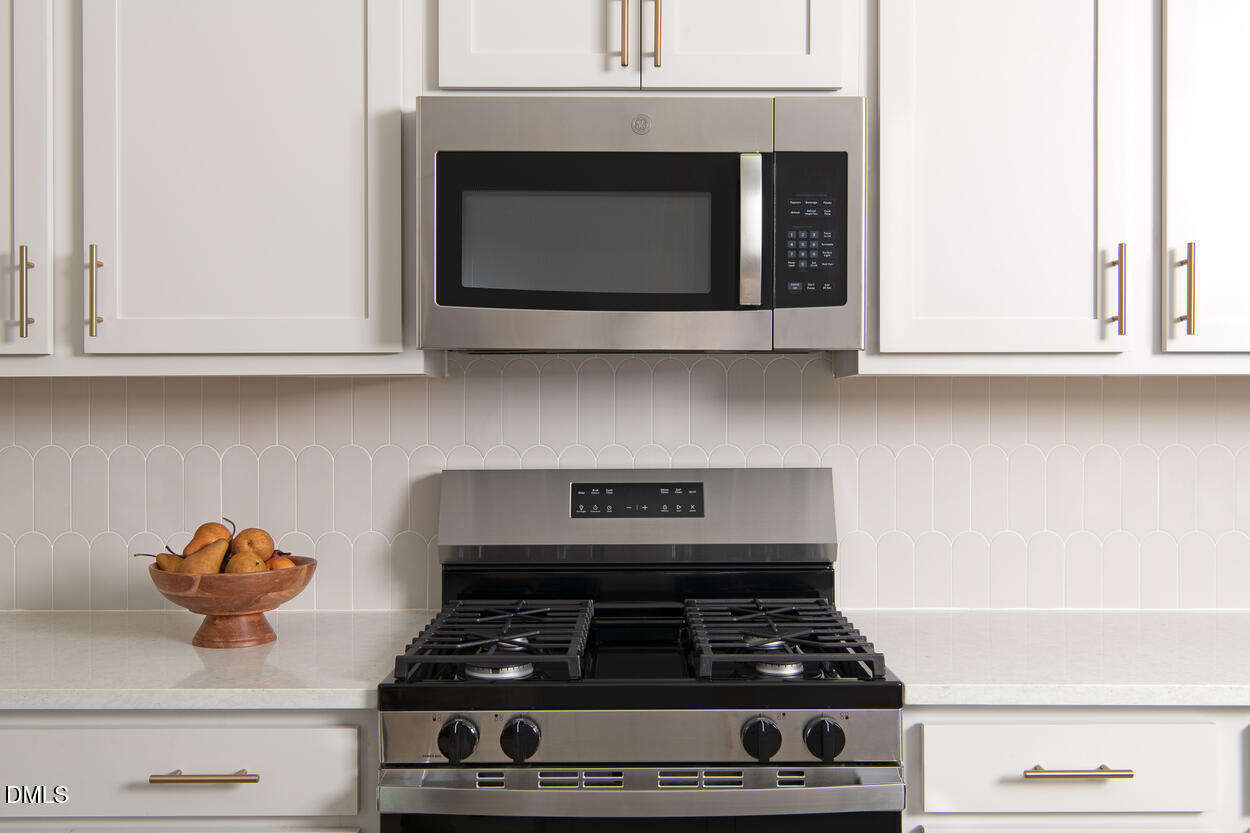 1511 Mirth Court Rolesville, NC 27571 - Photo 11 of 30 a kitchen with granite countertop white cabinets and black appliances