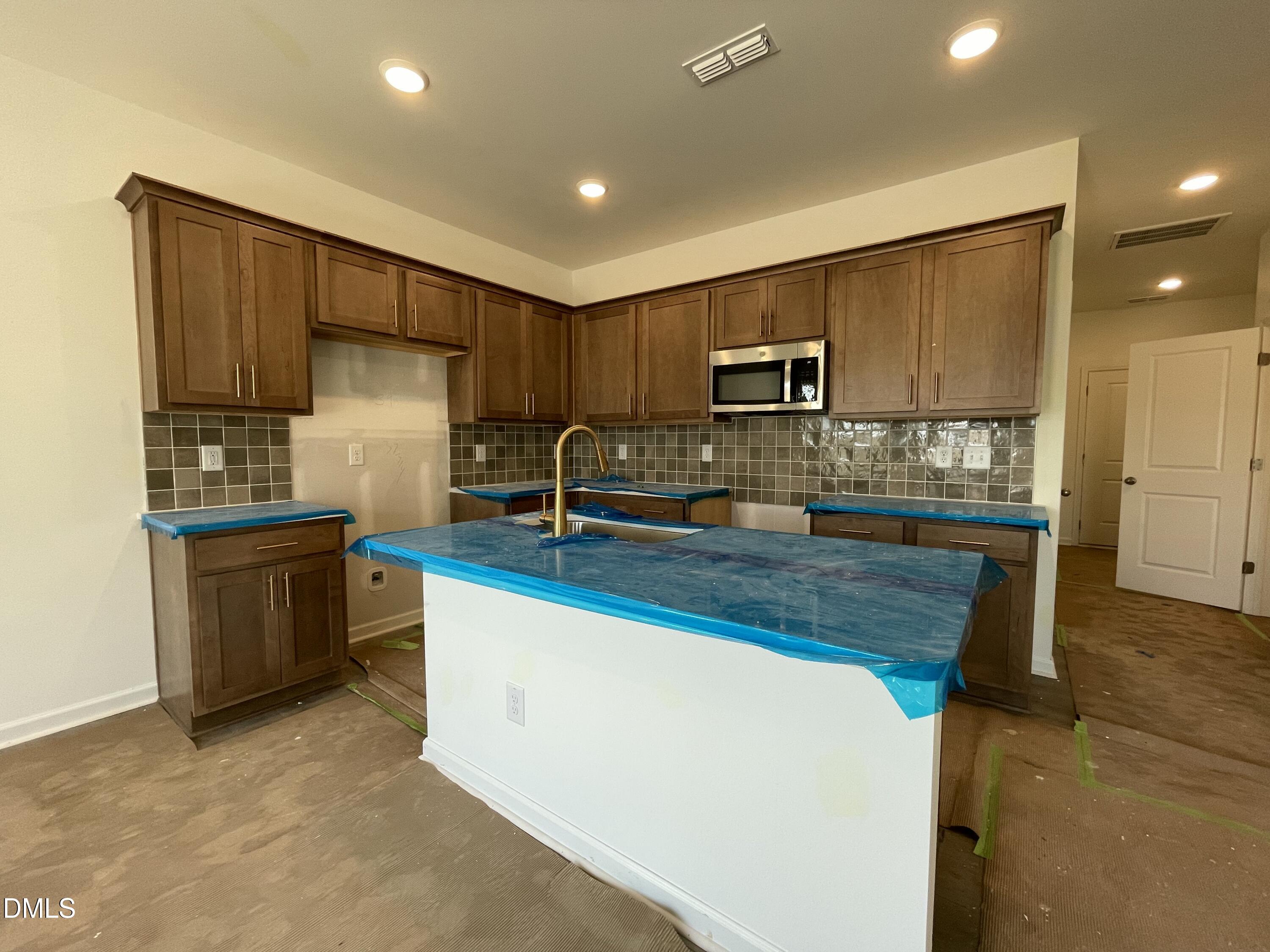 1511 Mirth Court Rolesville, NC 27571 - Photo 6 of 30 a kitchen with kitchen island granite countertop a refrigerator stove top oven and sink