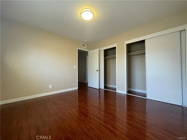 an empty room with wooden floor and natural light