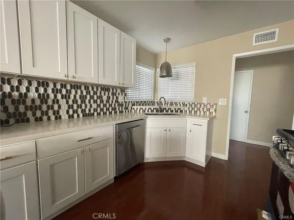 a kitchen with white cabinets and sink