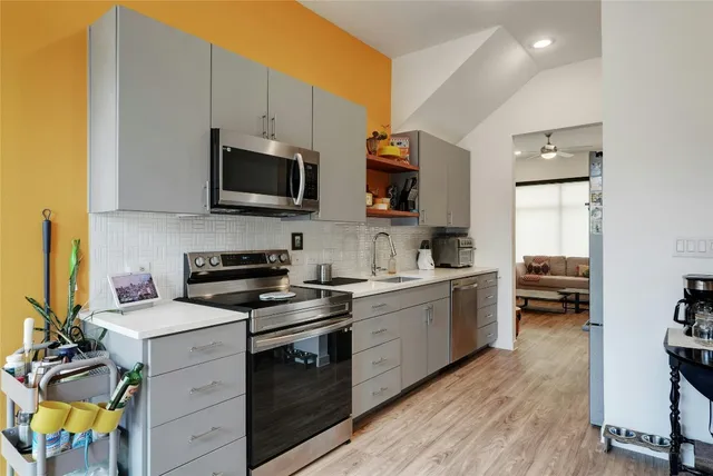 a kitchen with stainless steel appliances a stove sink microwave and cabinets