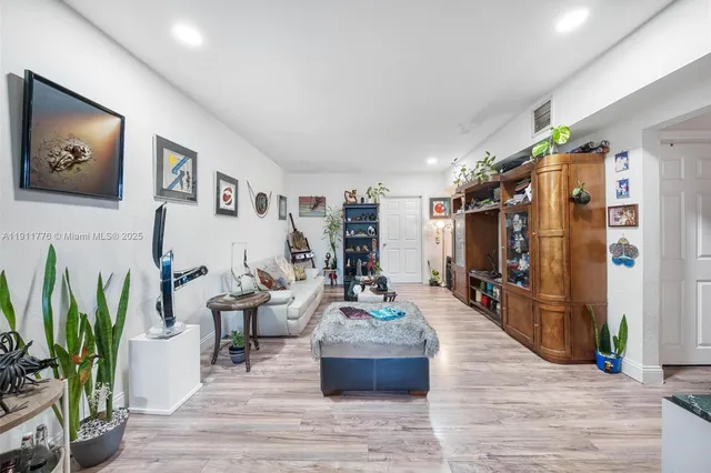 a living room with furniture a flat screen tv and a painting on the wall