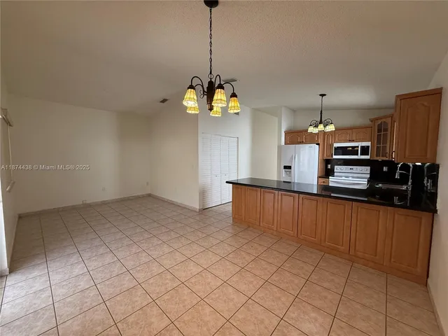 a front view of a house with a yard and potted plants