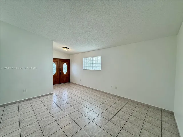 an empty room with wooden floor windows and closet