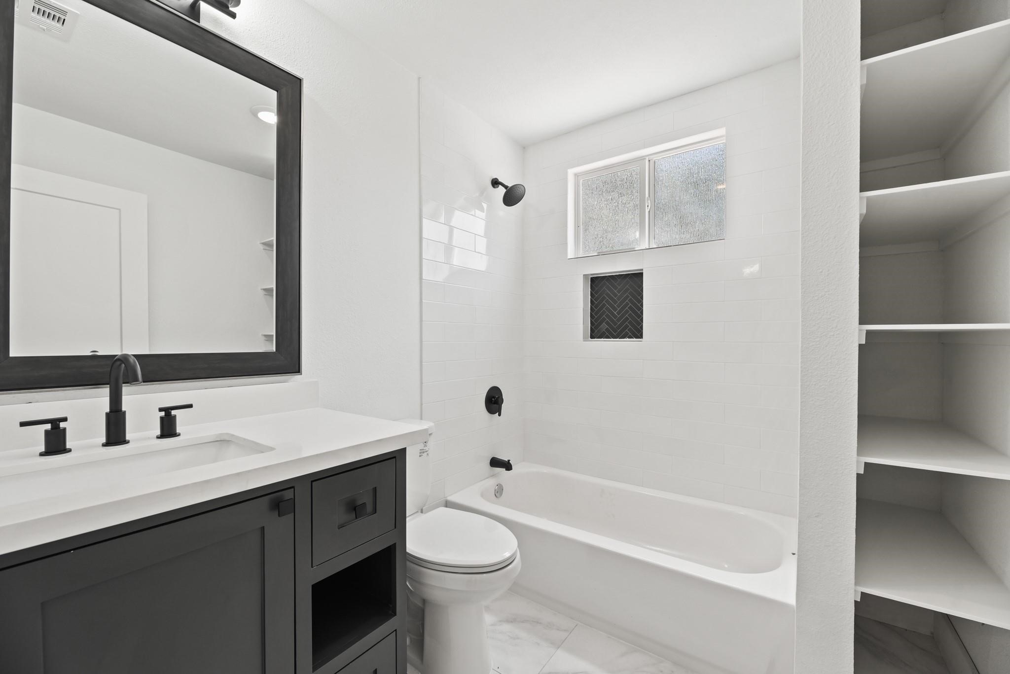 17068 Lively Road Waller, TX 77484 - Photo 19 of 29 a bathroom with a tub sink toilet and a mirror