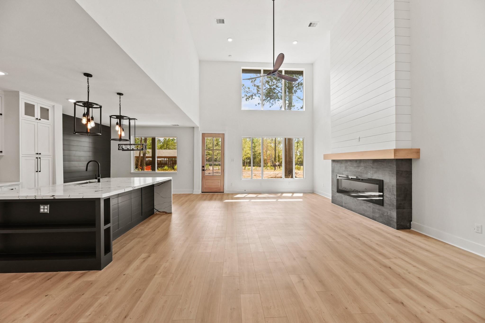 17068 Lively Road Waller, TX 77484 - Photo 3 of 29 a large kitchen with kitchen island a sink dishwasher a stove and a dining table with wooden floor
