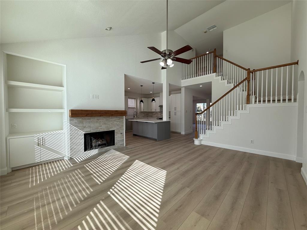 2254 Ash Grove Way Dallas, TX 75228 - Photo 15 of 23 a view of a livingroom with wooden floor a ceiling fan and staircase