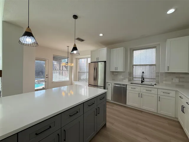 a kitchen with stainless steel appliances granite countertop a sink a refrigerator and a stove