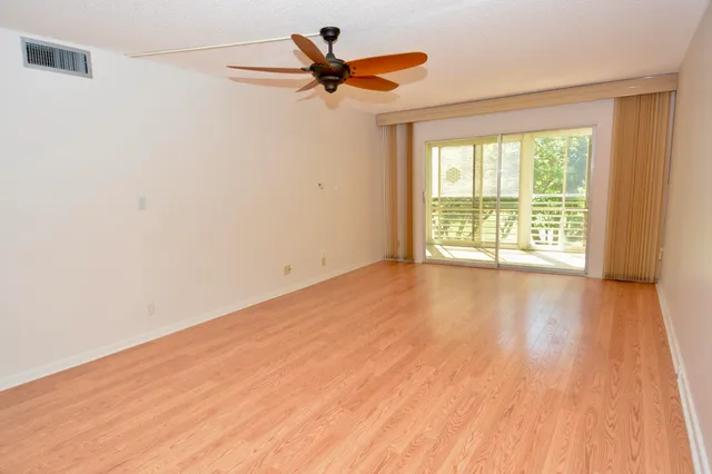 a view of a room with wooden floor and a ceiling fan
