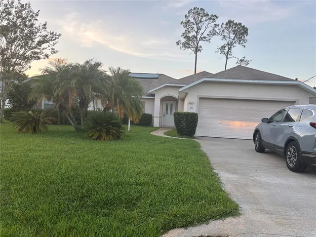 a front view of a house with a garden and parking
