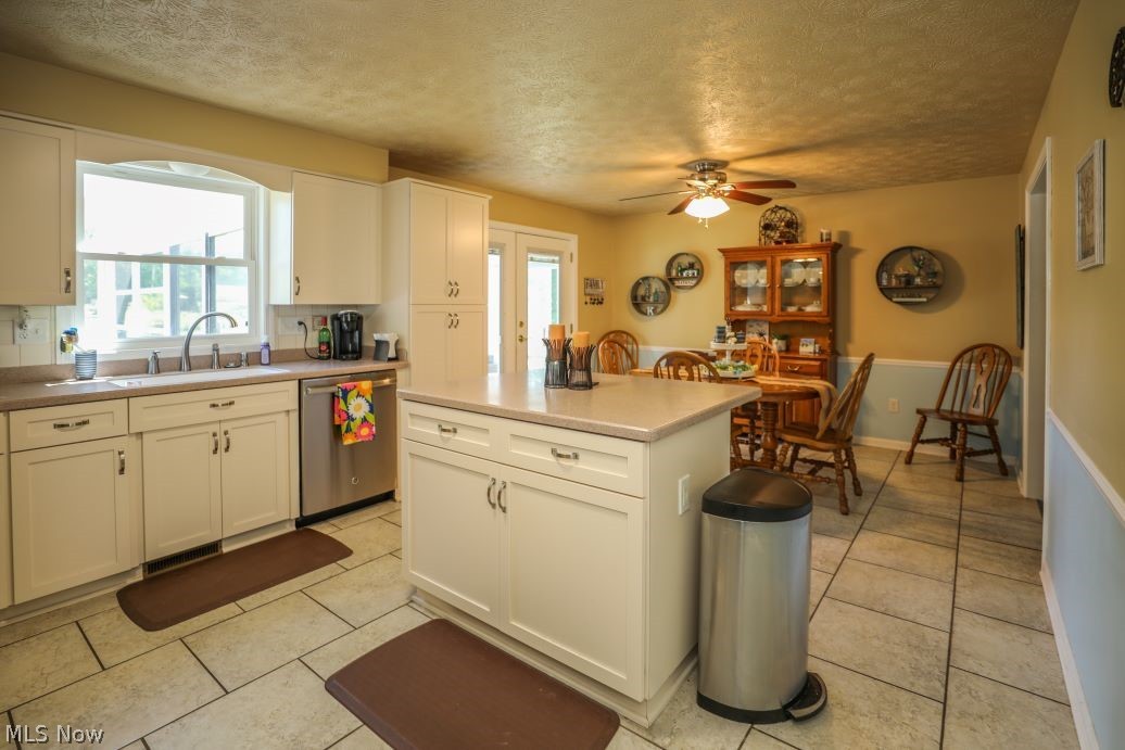 3022 Sandy Lake Road Ravenna, OH 44266 - Photo 21 of 41 Kitchen featuring stainless steel dishwasher, white cabinets, sink, ceiling fan, and light tile floors